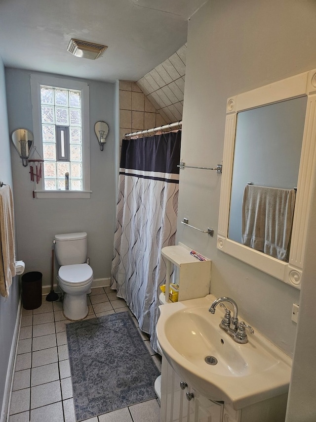 bathroom with tile patterned floors, toilet, vaulted ceiling, vanity, and walk in shower