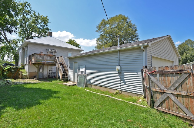 back of house featuring a wooden deck and a lawn