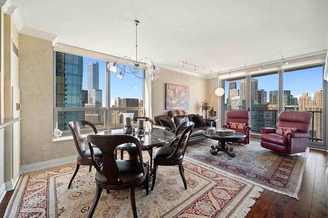 dining room with an inviting chandelier, crown molding, hardwood / wood-style flooring, and plenty of natural light