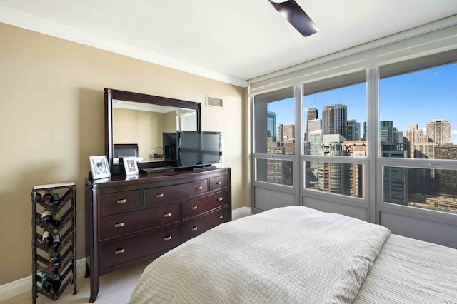 carpeted bedroom with crown molding and ceiling fan