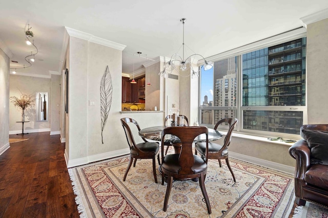 dining space featuring hardwood / wood-style flooring, ornamental molding, and an inviting chandelier