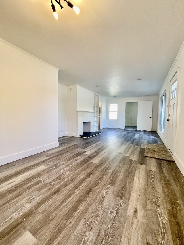 unfurnished living room with hardwood / wood-style flooring and ornamental molding