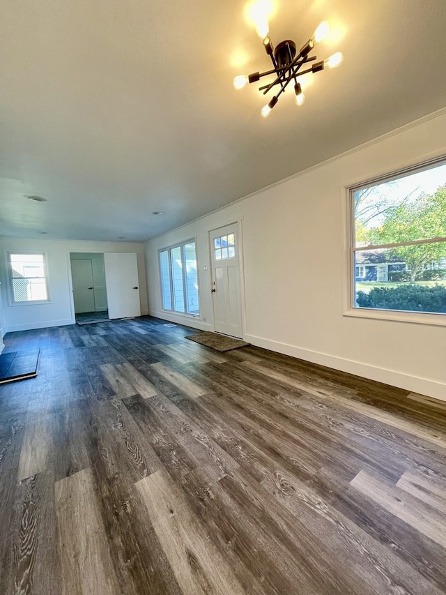 unfurnished living room with dark wood-type flooring and a healthy amount of sunlight