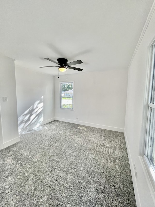 carpeted spare room with crown molding and ceiling fan