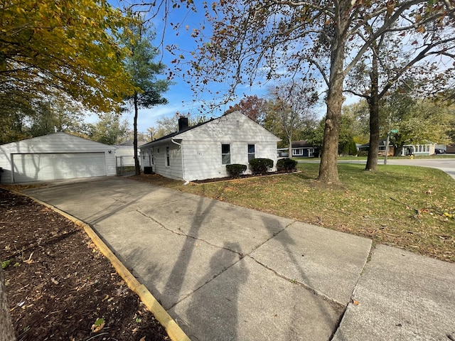 view of side of home with a lawn, an outbuilding, and a garage