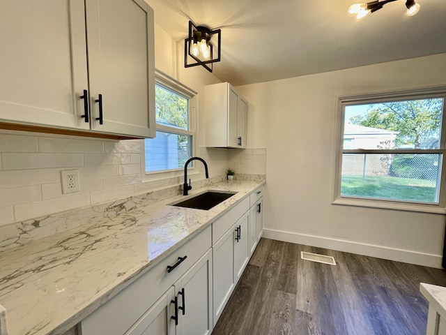 kitchen featuring white cabinets, a healthy amount of sunlight, sink, and dark wood-type flooring