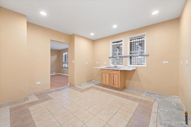 kitchen with sink, light brown cabinets, and light tile patterned floors