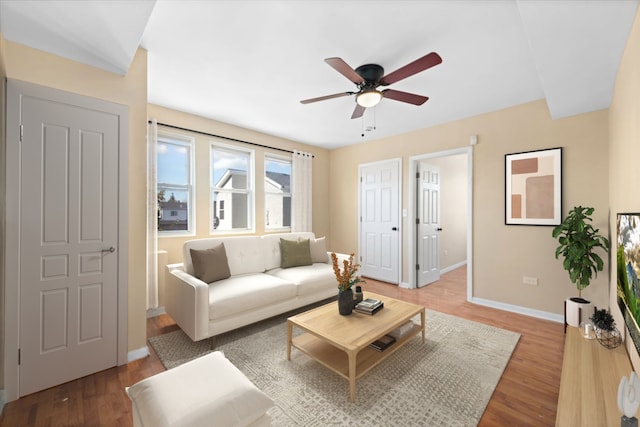 living room featuring ceiling fan and hardwood / wood-style flooring