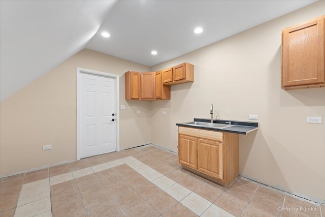 kitchen featuring light brown cabinetry, sink, vaulted ceiling, and light tile patterned floors