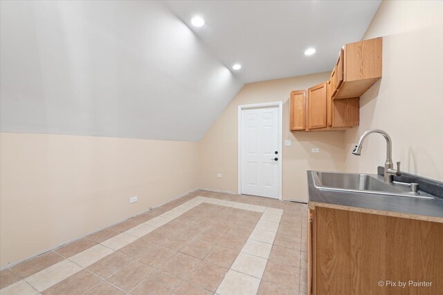 kitchen featuring vaulted ceiling, light tile patterned flooring, and sink