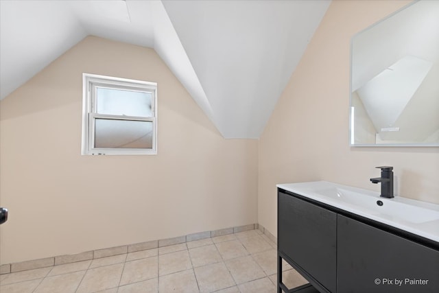 bathroom with vanity, vaulted ceiling, and tile patterned flooring