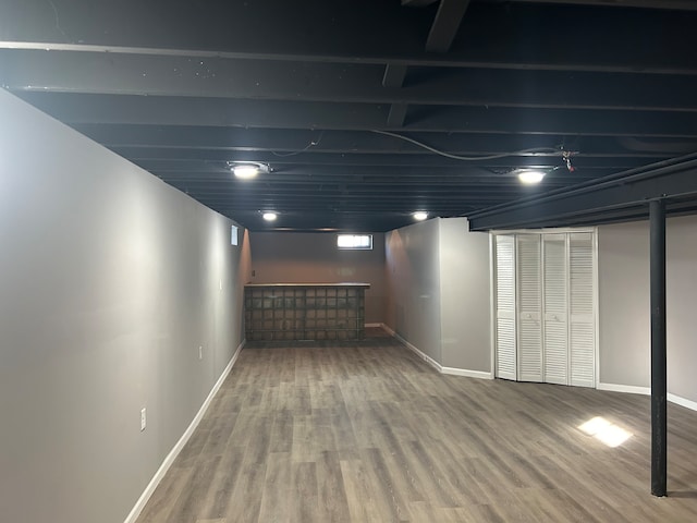 basement featuring hardwood / wood-style flooring and bar