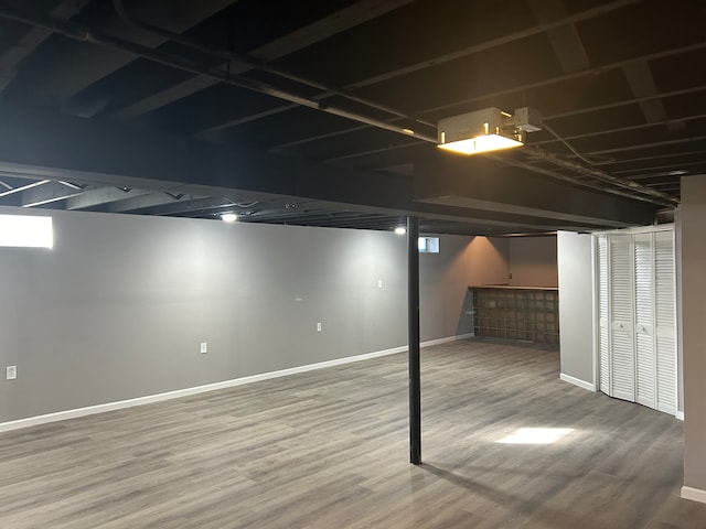 basement featuring wood-type flooring and indoor bar