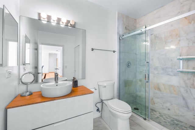 bathroom featuring vanity, toilet, and a shower with shower door