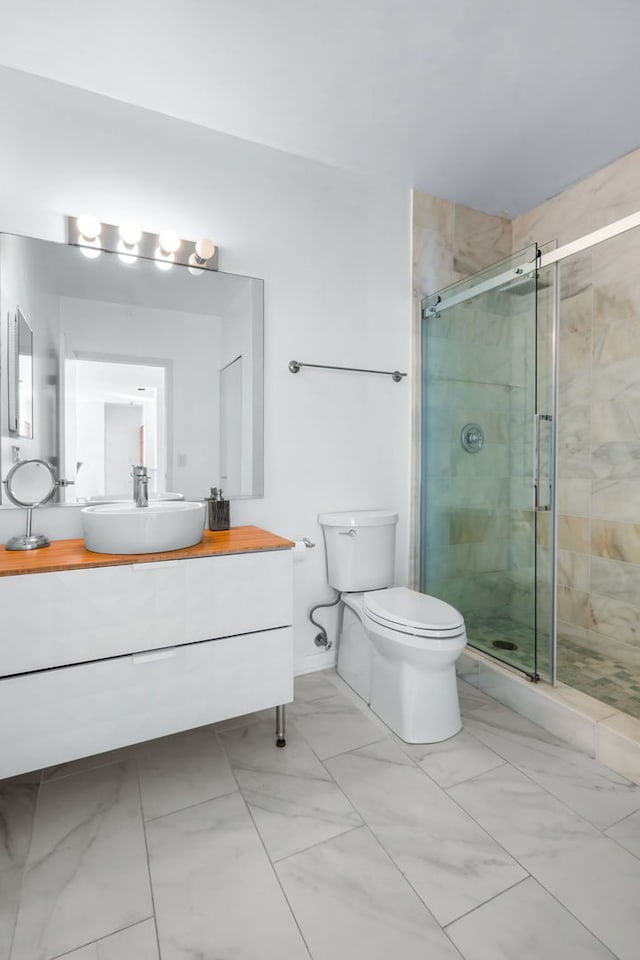 bathroom featuring vanity, an enclosed shower, and toilet