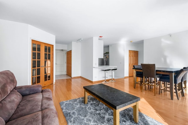 living room with french doors and light wood-type flooring