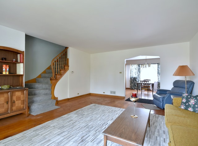 living room with a notable chandelier and wood-type flooring