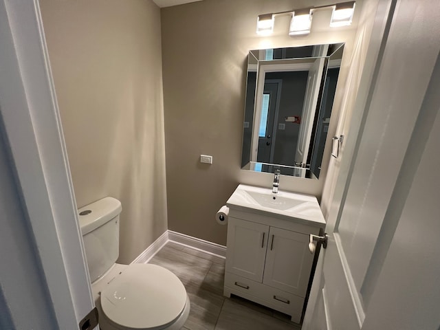 bathroom with vanity, hardwood / wood-style flooring, and toilet