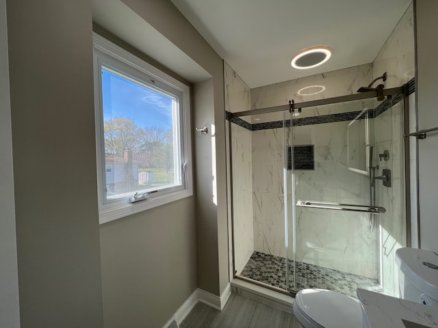 bathroom featuring toilet and an enclosed shower