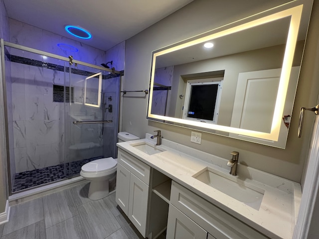 bathroom featuring vanity, toilet, and a shower with shower door