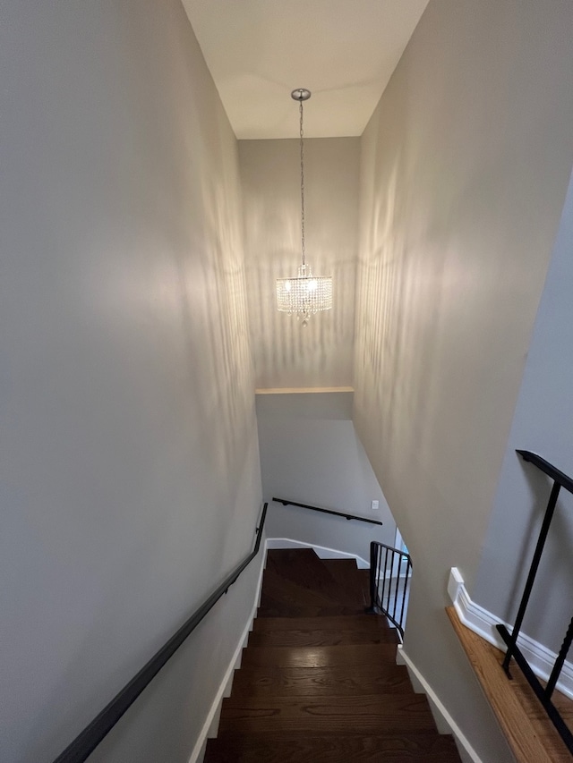 staircase with a chandelier and hardwood / wood-style flooring