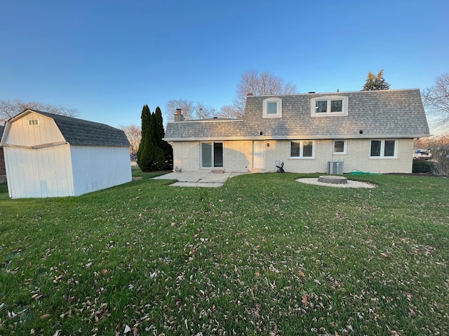 rear view of property featuring a patio area, a storage unit, cooling unit, and a lawn