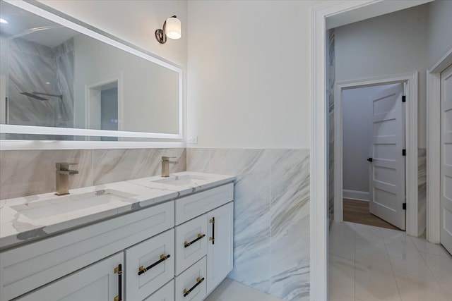 bathroom with vanity, walk in shower, tile walls, and tile patterned flooring