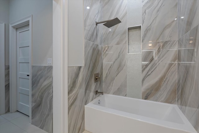 bathroom with tiled shower / bath combo, tile patterned floors, and tile walls