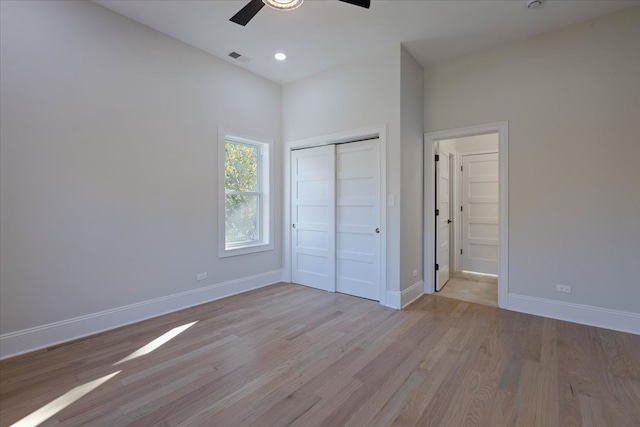 unfurnished bedroom featuring light hardwood / wood-style flooring, a closet, and ceiling fan