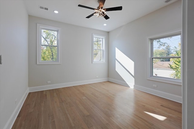 unfurnished room with light hardwood / wood-style floors, a wealth of natural light, and ceiling fan