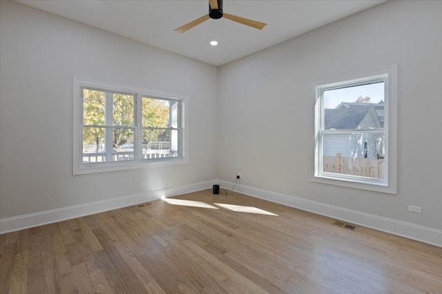 spare room featuring ceiling fan, light hardwood / wood-style floors, and plenty of natural light