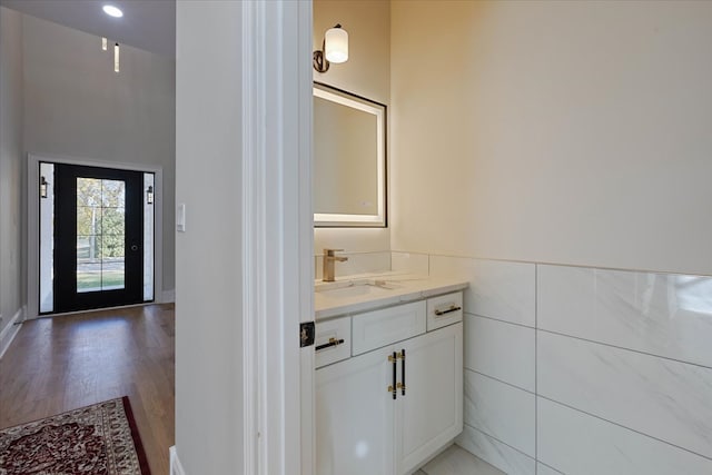 bathroom featuring vanity, hardwood / wood-style flooring, and tile walls