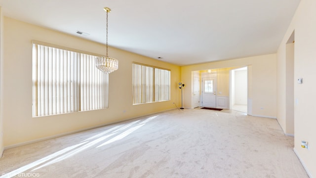 unfurnished room with a chandelier and light carpet