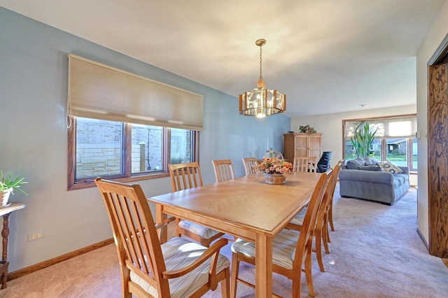 carpeted dining space featuring a chandelier