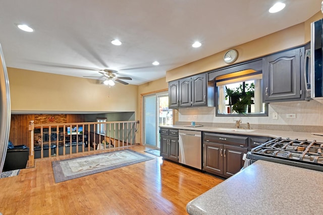 kitchen with tasteful backsplash, ceiling fan, appliances with stainless steel finishes, light hardwood / wood-style floors, and sink