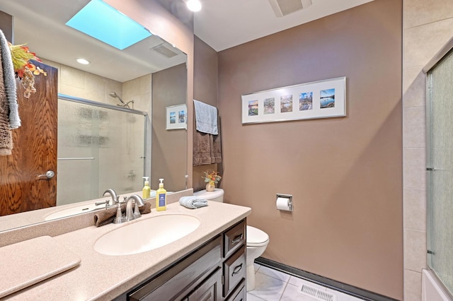 bathroom featuring toilet, tile patterned flooring, walk in shower, vanity, and a skylight