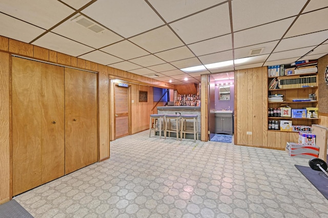 bar with wood walls and a paneled ceiling