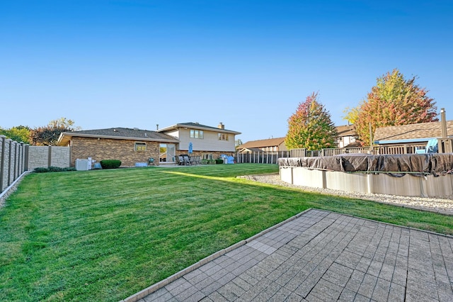 view of yard with cooling unit and a patio