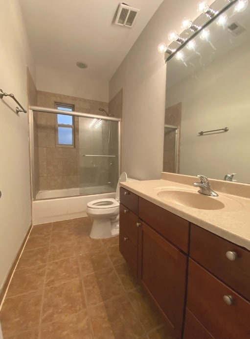 full bathroom with vanity, toilet, and shower / bath combination with glass door