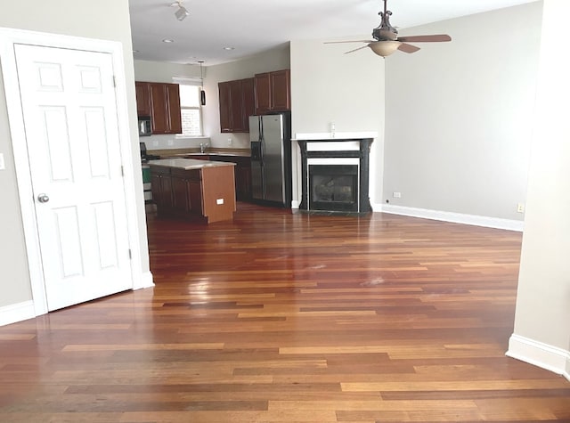 kitchen with dark hardwood / wood-style floors, ceiling fan, stainless steel appliances, and a kitchen island