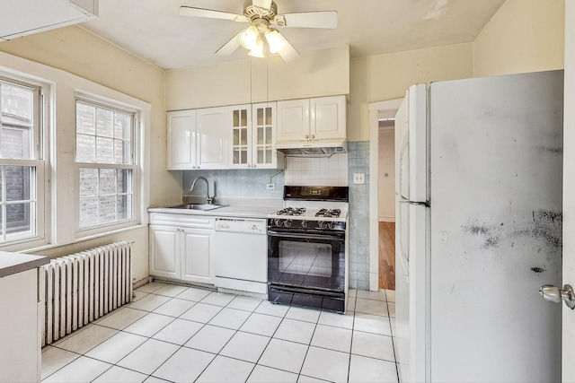 kitchen with white appliances, white cabinets, sink, and radiator