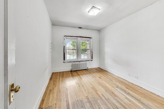 empty room with radiator heating unit and wood-type flooring