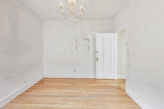 unfurnished room with crown molding, an inviting chandelier, and hardwood / wood-style floors