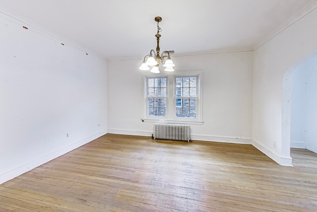 unfurnished dining area with a chandelier, crown molding, radiator heating unit, and light wood-type flooring