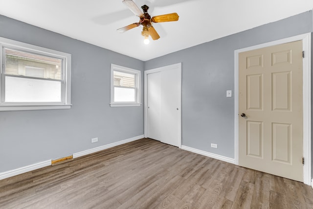 empty room with ceiling fan and light wood-type flooring