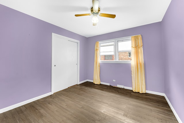 unfurnished bedroom featuring a closet, wood-type flooring, and ceiling fan