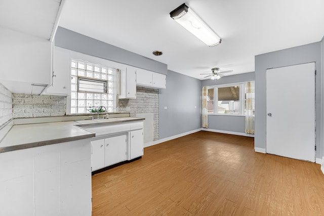 kitchen featuring white cabinetry, light hardwood / wood-style floors, sink, and ceiling fan