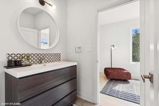 bathroom featuring vanity, hardwood / wood-style floors, and tasteful backsplash