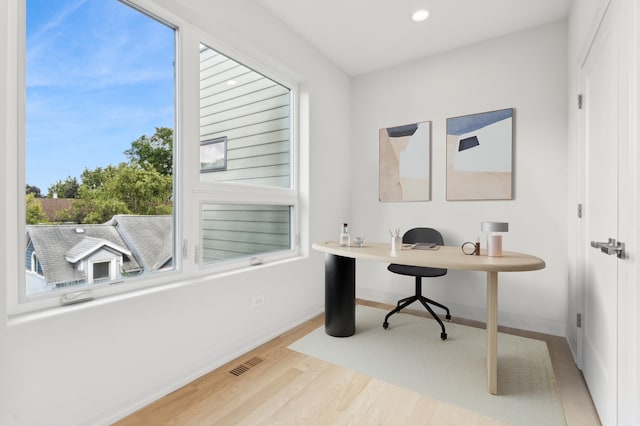 home office with a wealth of natural light and light wood-type flooring