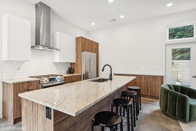 kitchen featuring a kitchen island with sink, white cabinetry, high quality appliances, and sink